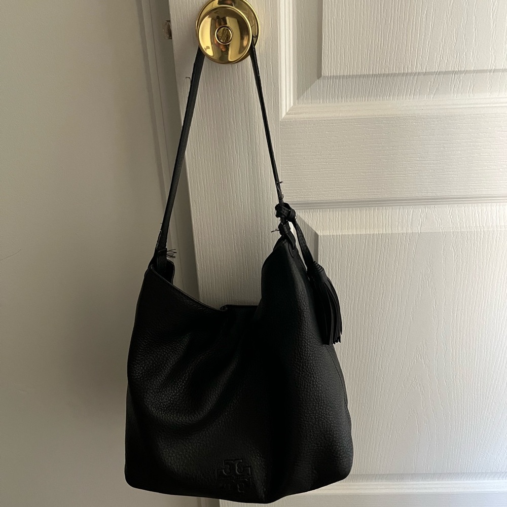 Black leather Tory Burch handbag with single snap closure.  This bag is worn